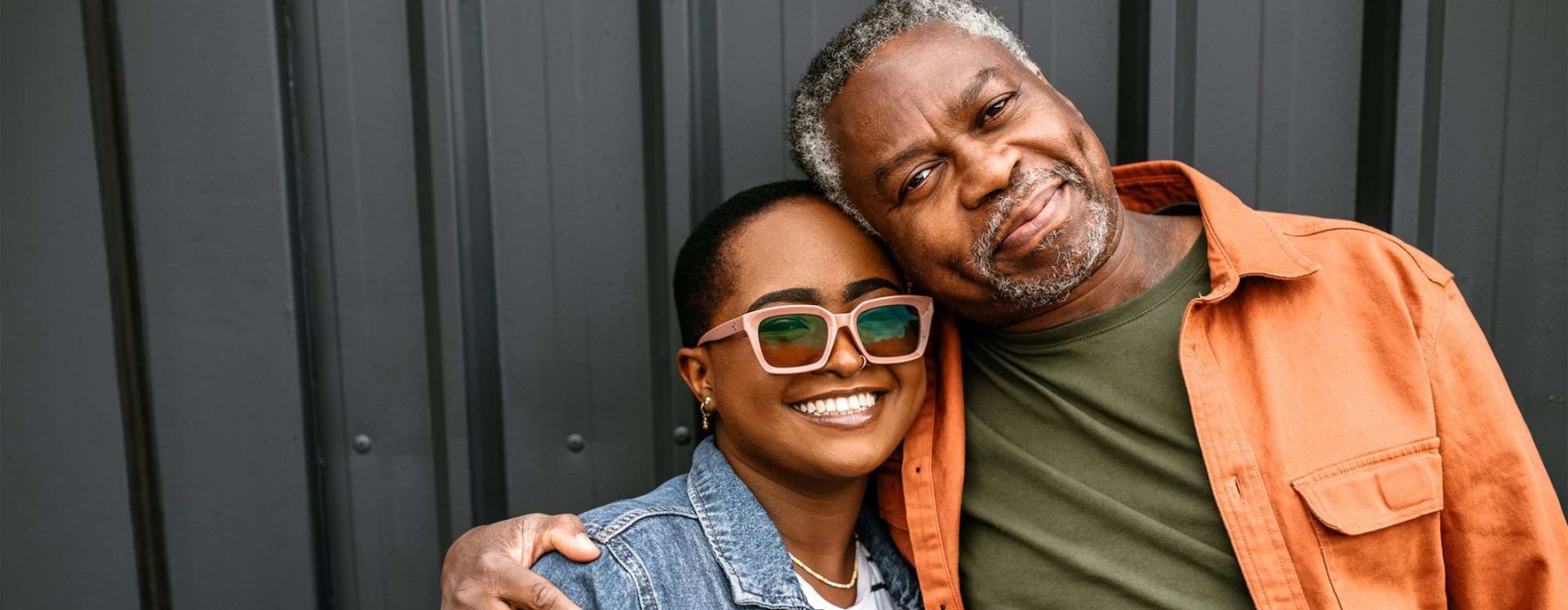 a man and woman smiling while hugging