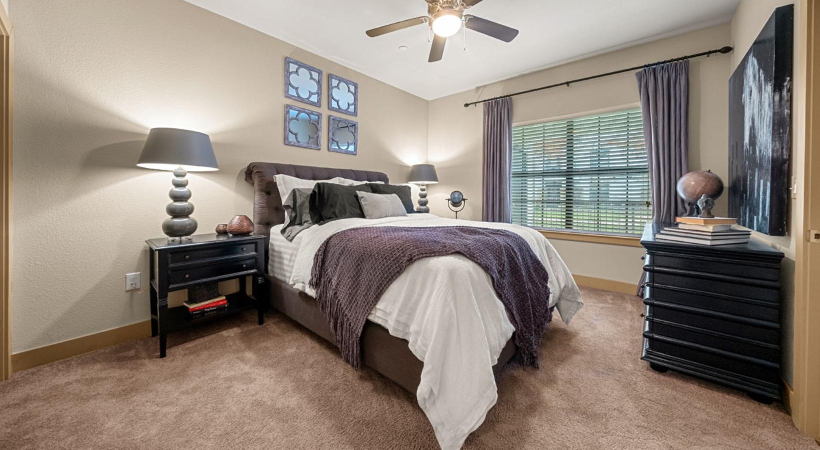 a bedroom with a bed and a fan