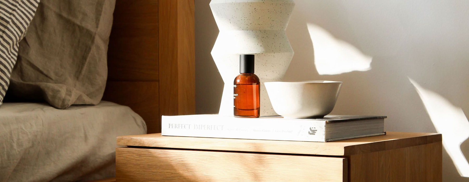 a bed with a nightstand and a lamp